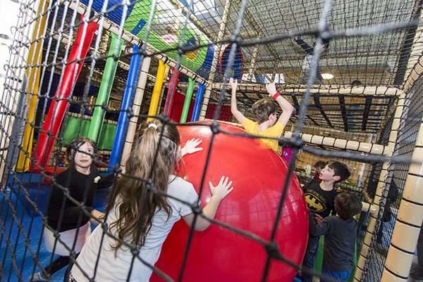 Bambini che spingono un pallone gigante dentro la struttura del playground