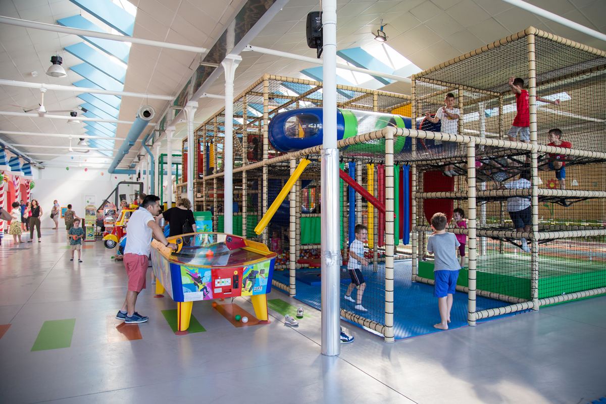 Il salone del Birbanti Village con la grande struttura del playground, gli air hockey e i bambini che giocano